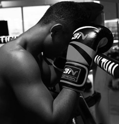 Adult boxing gloves being worn by a boxer training, emphasizing fitness and martial arts.
